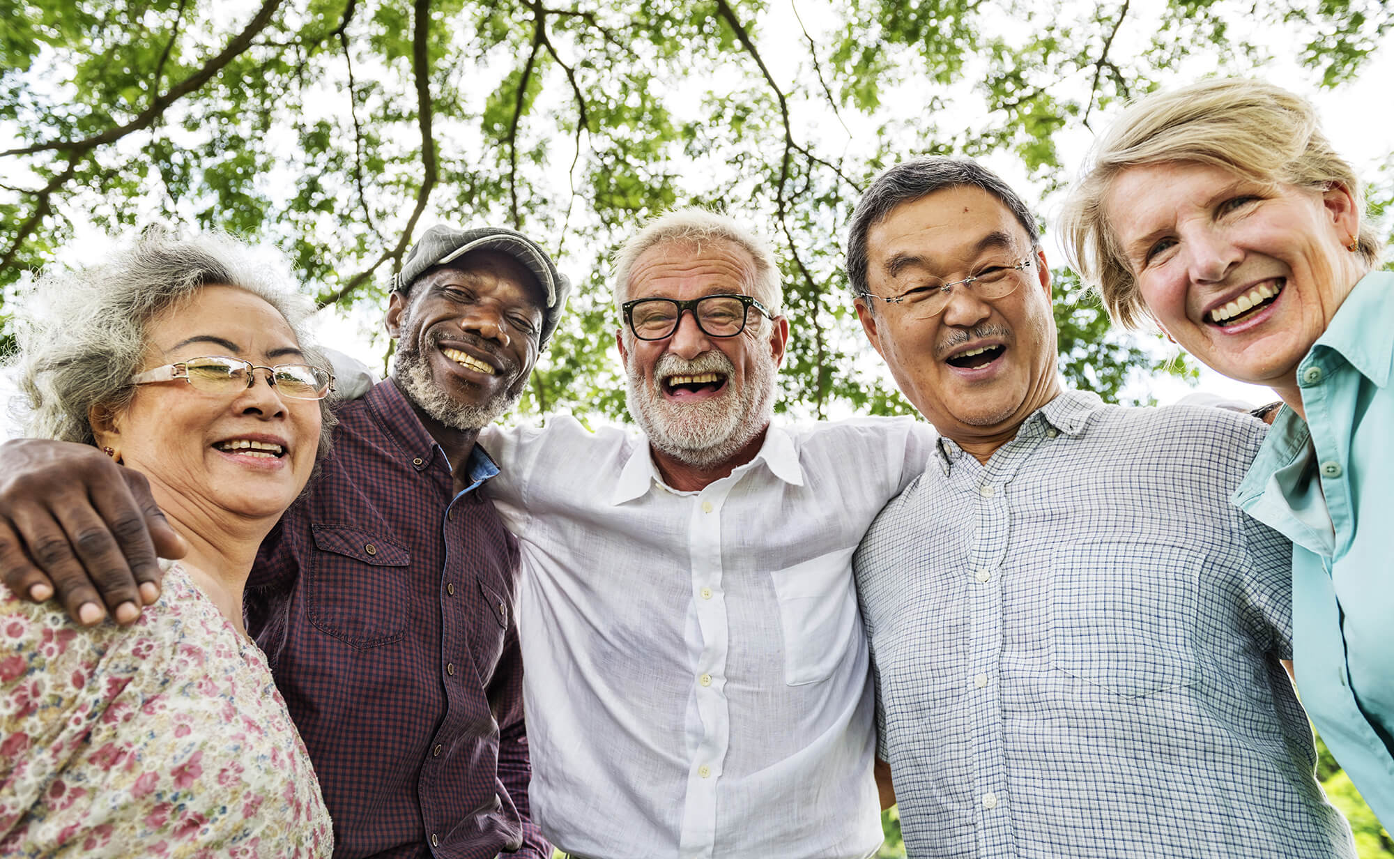 Elderly Group Smiling With Arms Around Shoulders